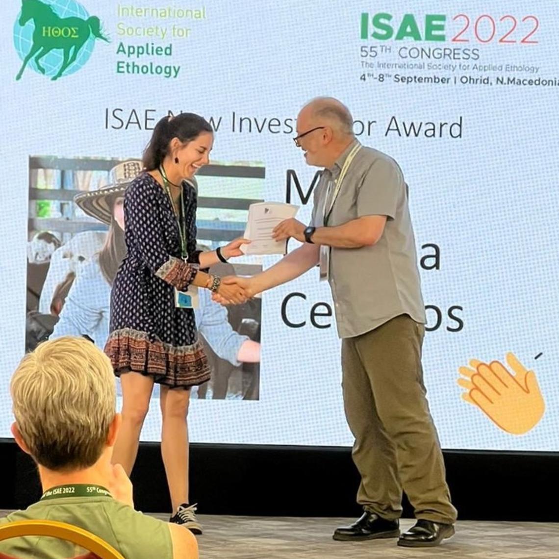 Dr. Ceballos shaking hands with a man as she receives her New Investigator Award. 