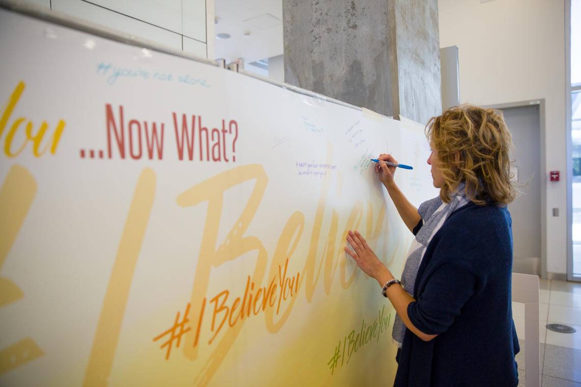 Sexual Violence Support Advocate Carla Bertsch adds her voice to the #IBelieveYou graffiti wall on campus. Photos by Riley Brant, University of Calgary 