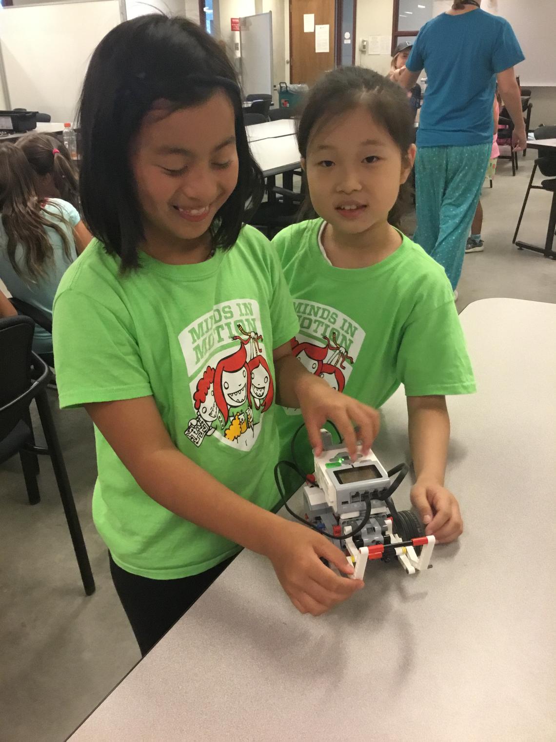 Two girls built Lego Mindstorms robots in a science and engineering camp.