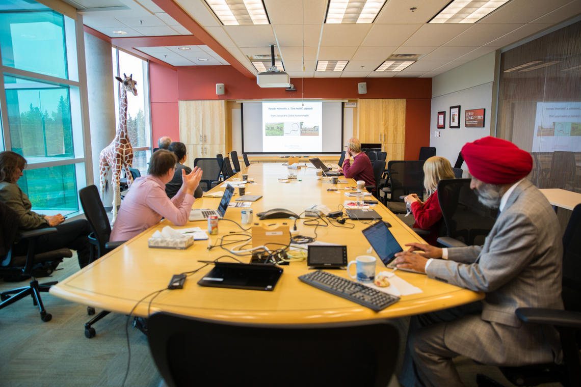 Researchers gather to present their international research projects to Dr. Thevasagayam. 