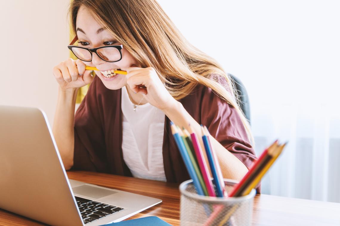 Very stressed out woman eats her pencil