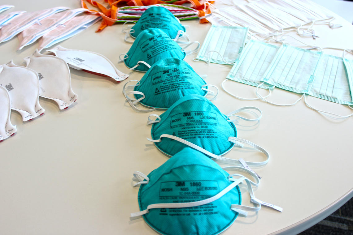 Six types of medical masks used in this study laid out on a table, with focus on the N95 masks