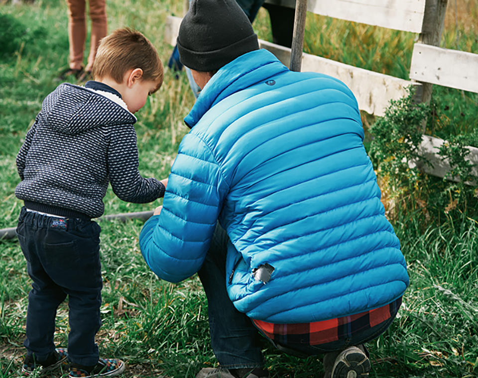 Rod Olson, a founding member of the YYC Growers and Distributors cooperative, and his son, examine a plant near the irrigation pond at Happiness by the Acre farm.