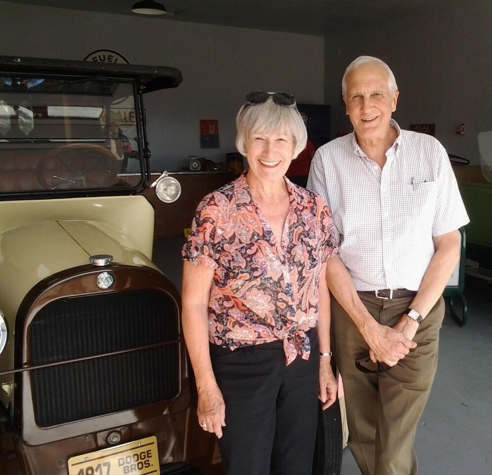 Woman and man standing in front of an antique car