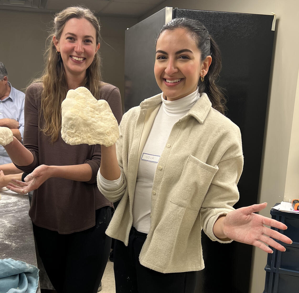 Sarah Welsh, left, and Nour Hassan try baking bread at the launch of the kitchen program.