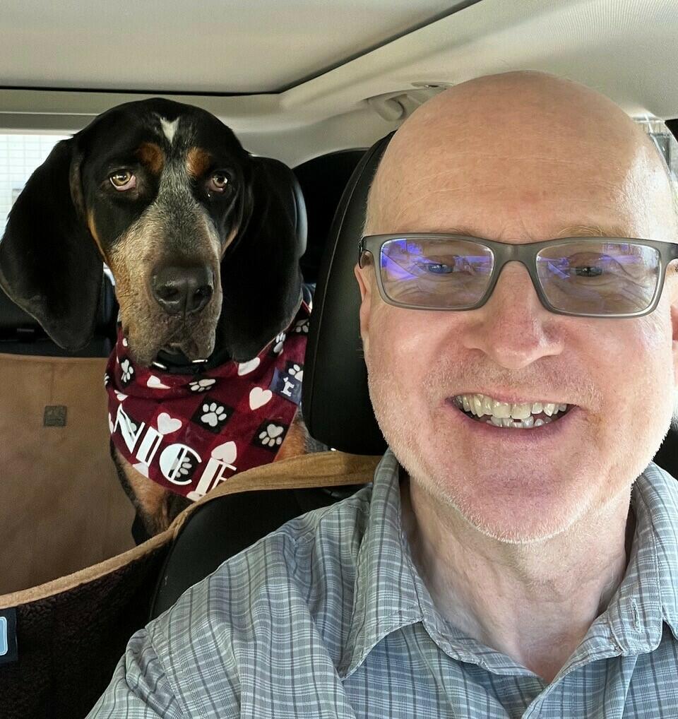 Brent Clute with his dog, who is wearing a bandana around its neck