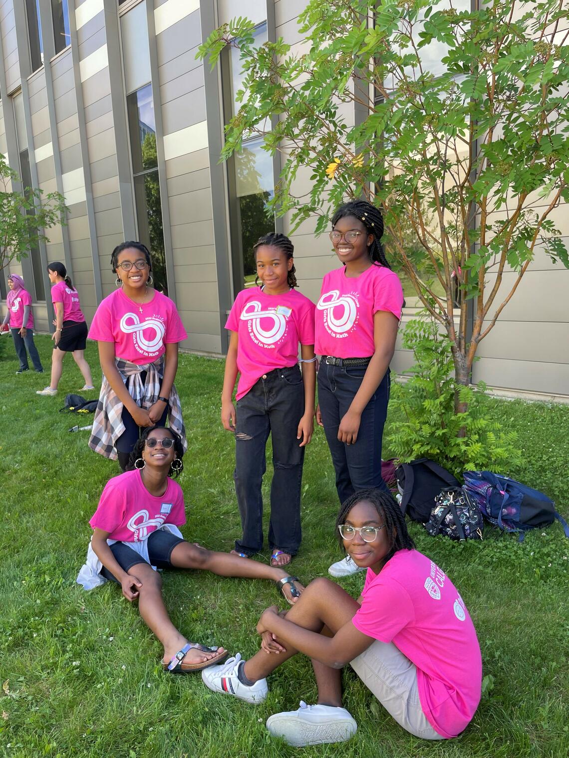 Girls' math camp participants in pink t-shirts, standing outside