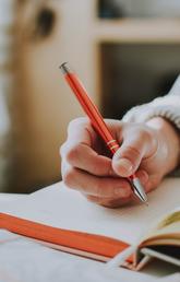 Person holding orange pen