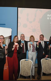 UCalgary faculty and staff hold up their microbiome personality cards. 