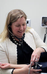 Kara Nerenberg takes a woman's blood pressure.	