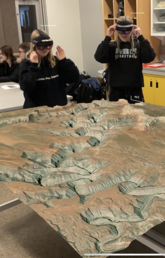 Geoscience students, from left,  Nicole Garner, Emma Hicklin, Kylie Tiedje, and Nichol Gillan use the HoloLens during a geoscience lab (HoloLens image superimposed)
