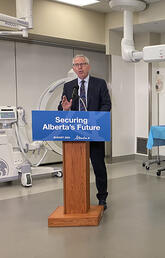 UCalgary President and Vice Chancellor Dr. Ed McCauley, PhD, speaks at a Foothills Campus press conference, while Jason Copping, Minister of Health (L) and Demetrios Nicolaides, Minister of Advanced Education look on