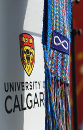 Metis sash and UCalgary logo with teepee in background