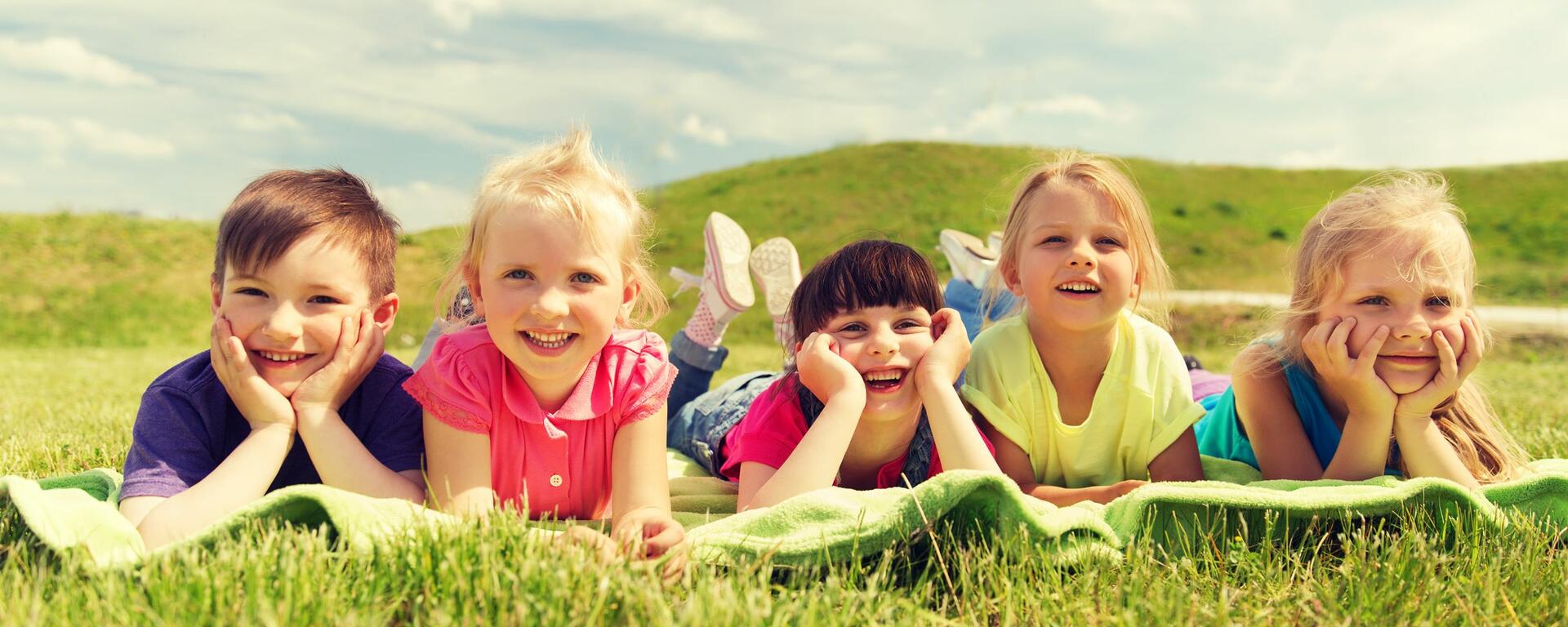 Kids in field with books 