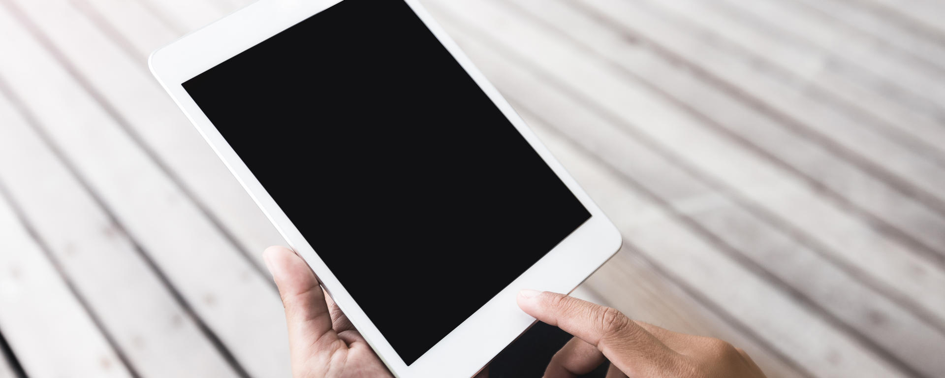 Hands holding an iPad.