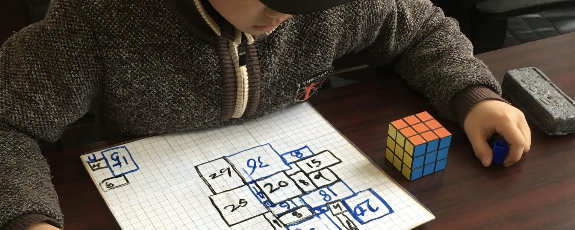 A third grade is playing their own redesigned game which they created using ideas from the board game "Inversé" and the Chinese game "Go".