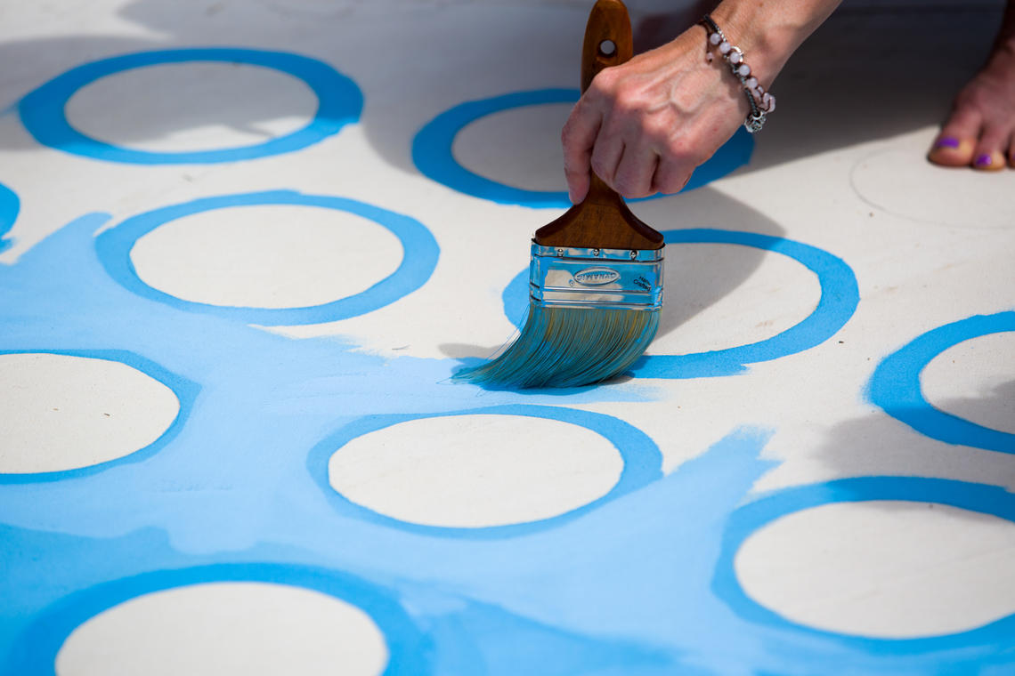 A hand painting blue and white circles