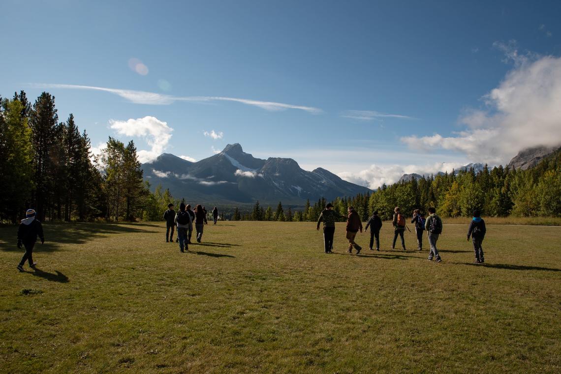 Group of students in a field with mountains in the background