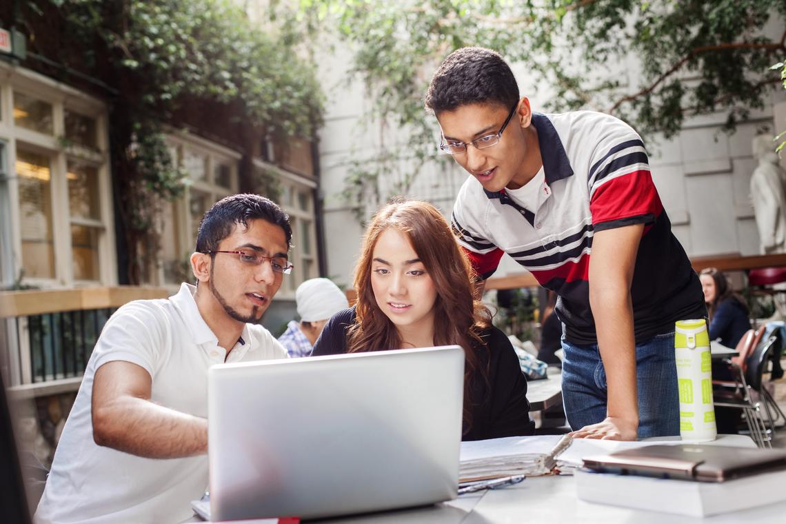 University students gather around a laptop