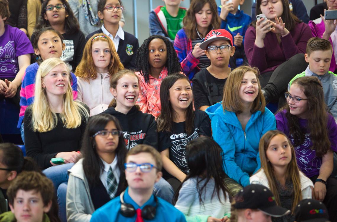 A group of children watching a show in an auditorium
