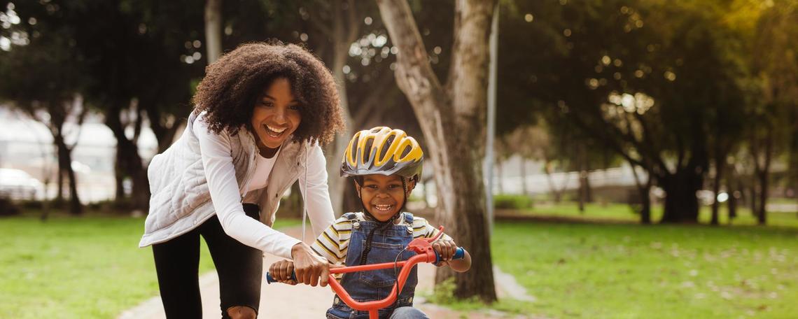 Mother assisting son to ride a bike