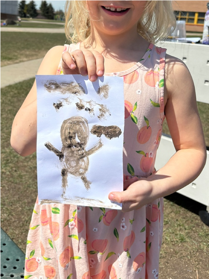 Child holding drawing of dirt