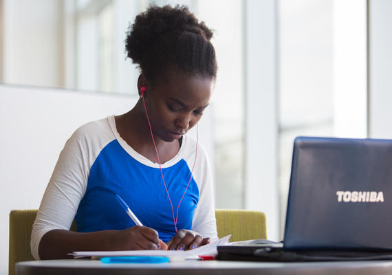 Student is writing in front of a computer