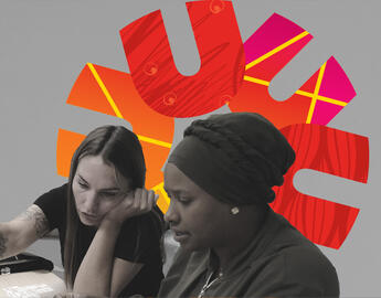 Two women reading textbook